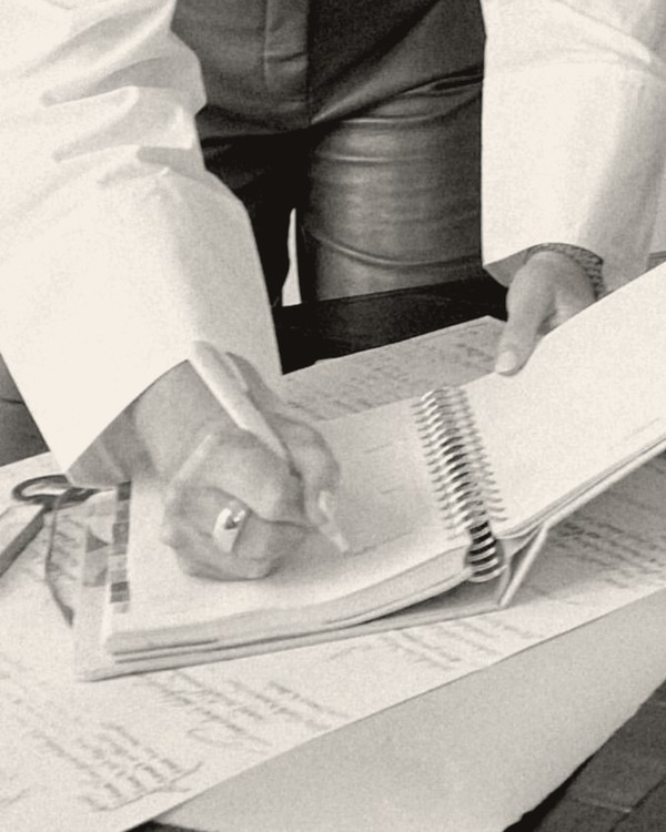 Hands writing in a planner